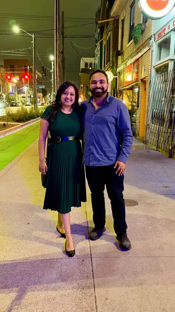 Akhil standing with a woman on a city sidewalk in the evening