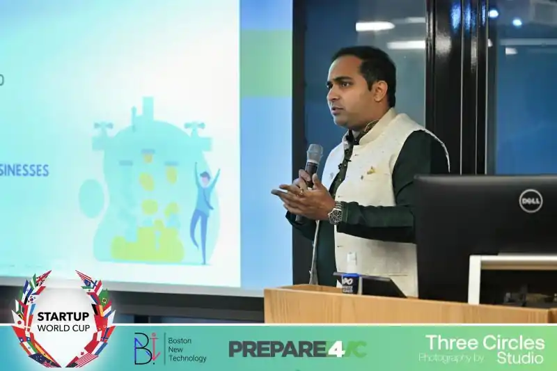 Akhil presenting with a microphone beside a projected slide.